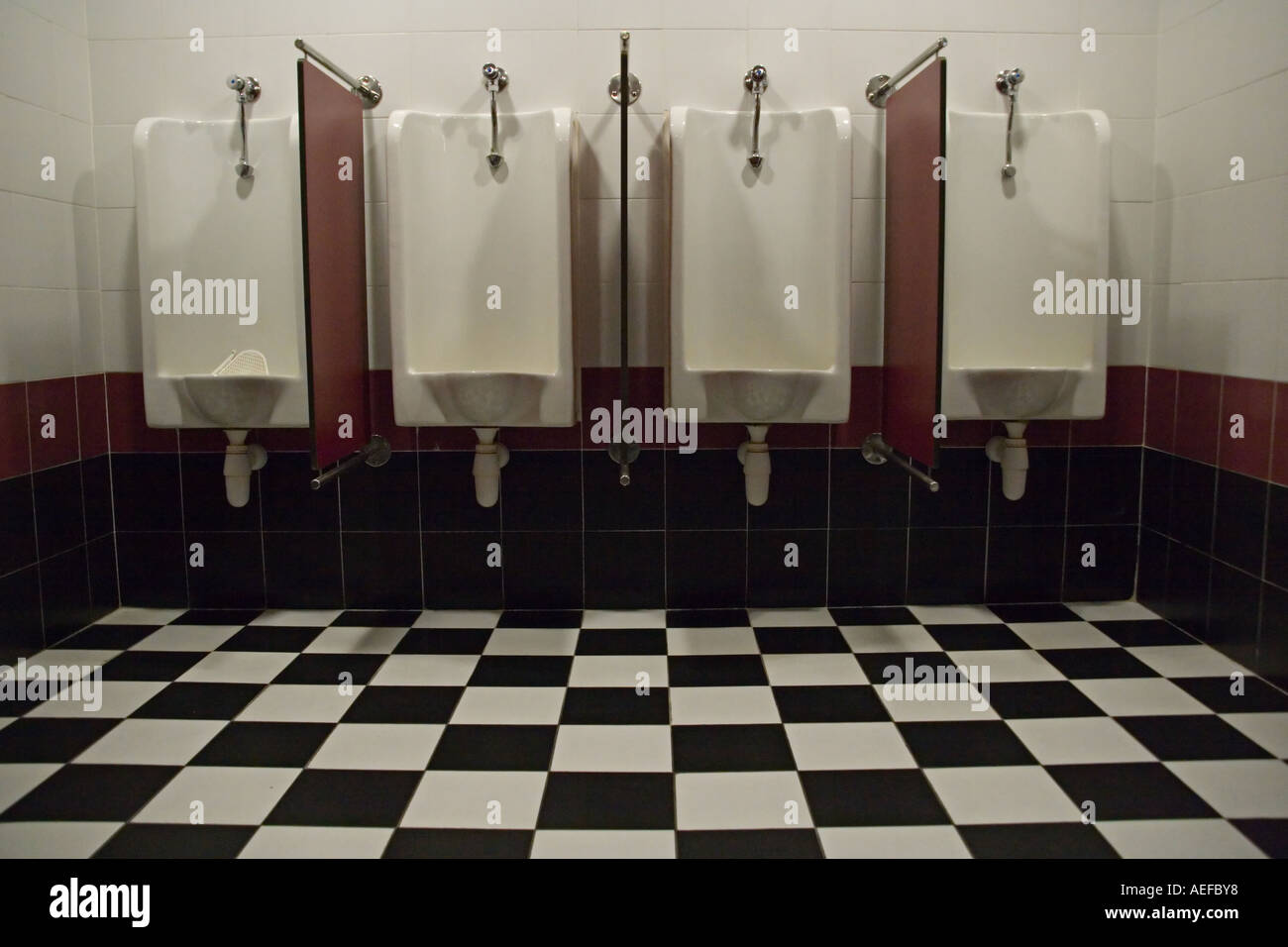 https://c8.alamy.com/comp/AEFBY8/stock-photo-of-a-public-men-s-room-with-four-urinals-showing-a-black-AEFBY8.jpg