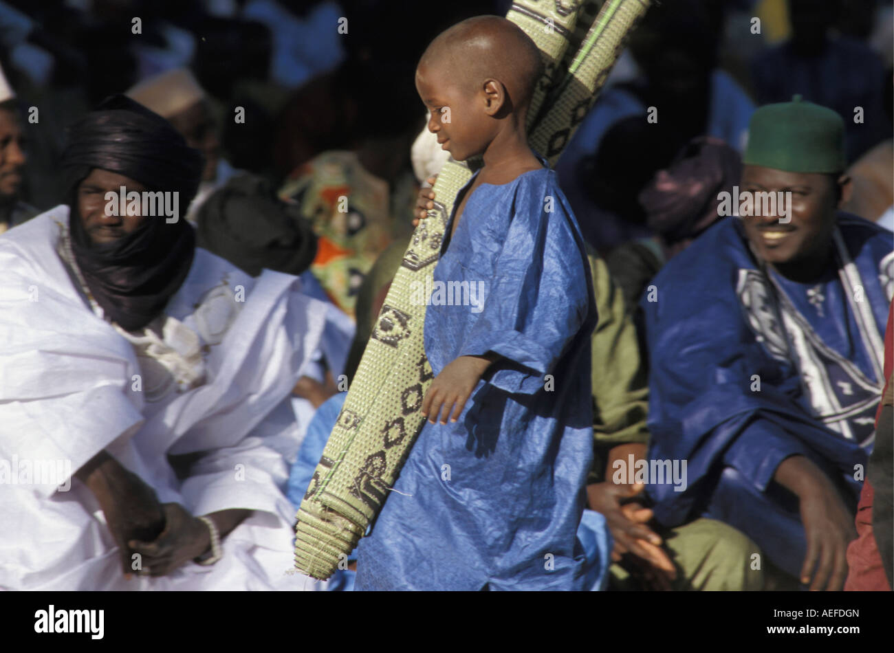 Mali Gao, Boy holding praying mat going to mosque Stock Photo Alamy