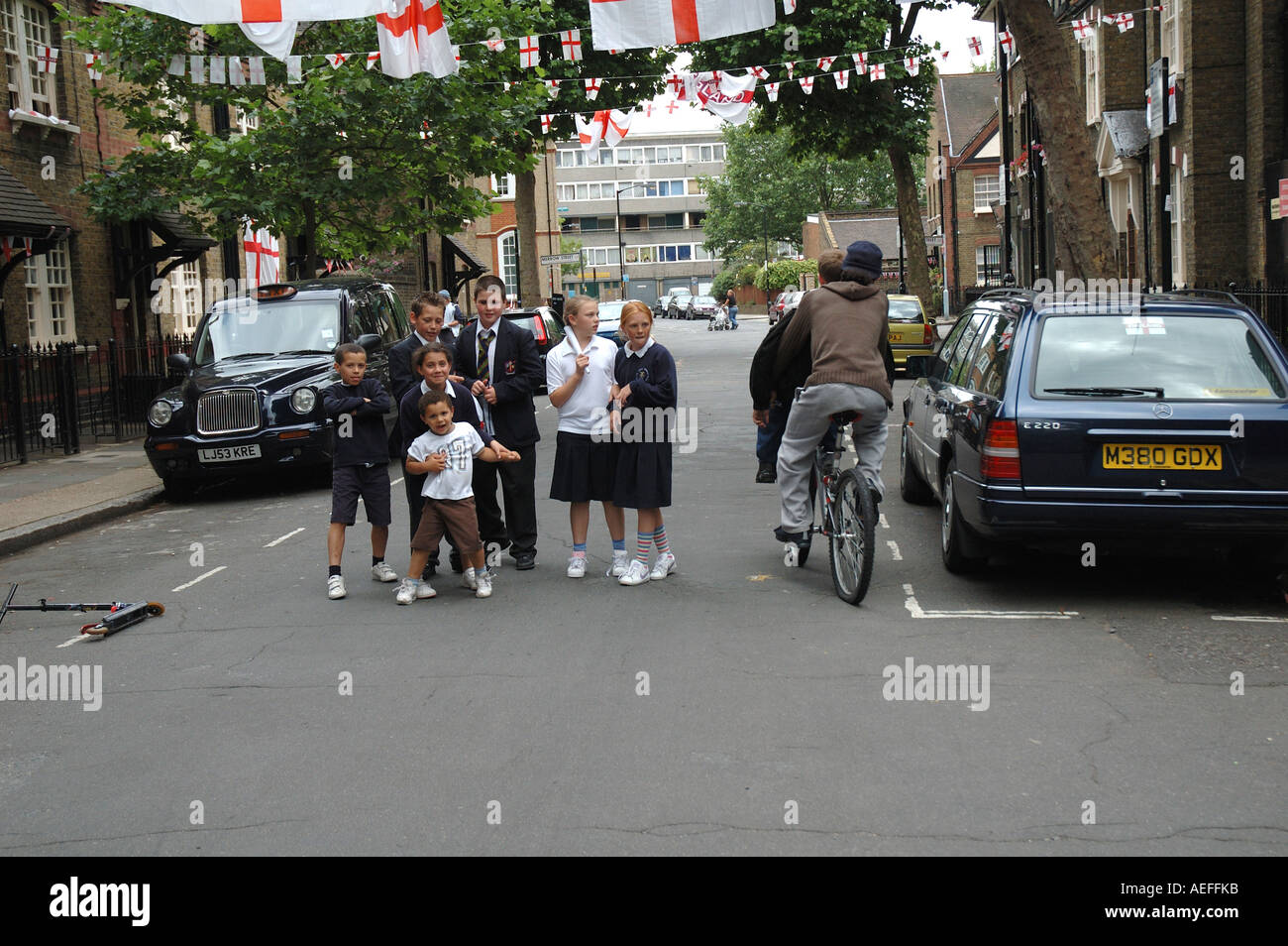 School children of mixed ages on way home from school posing in middle of street at time of World cup final Stock Photo