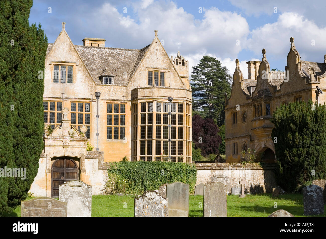 The Jacobean manor and gatehouse of Stanway House seen from the churchyard in the Cotswold village of Stanway, Gloucestershire Stock Photo
