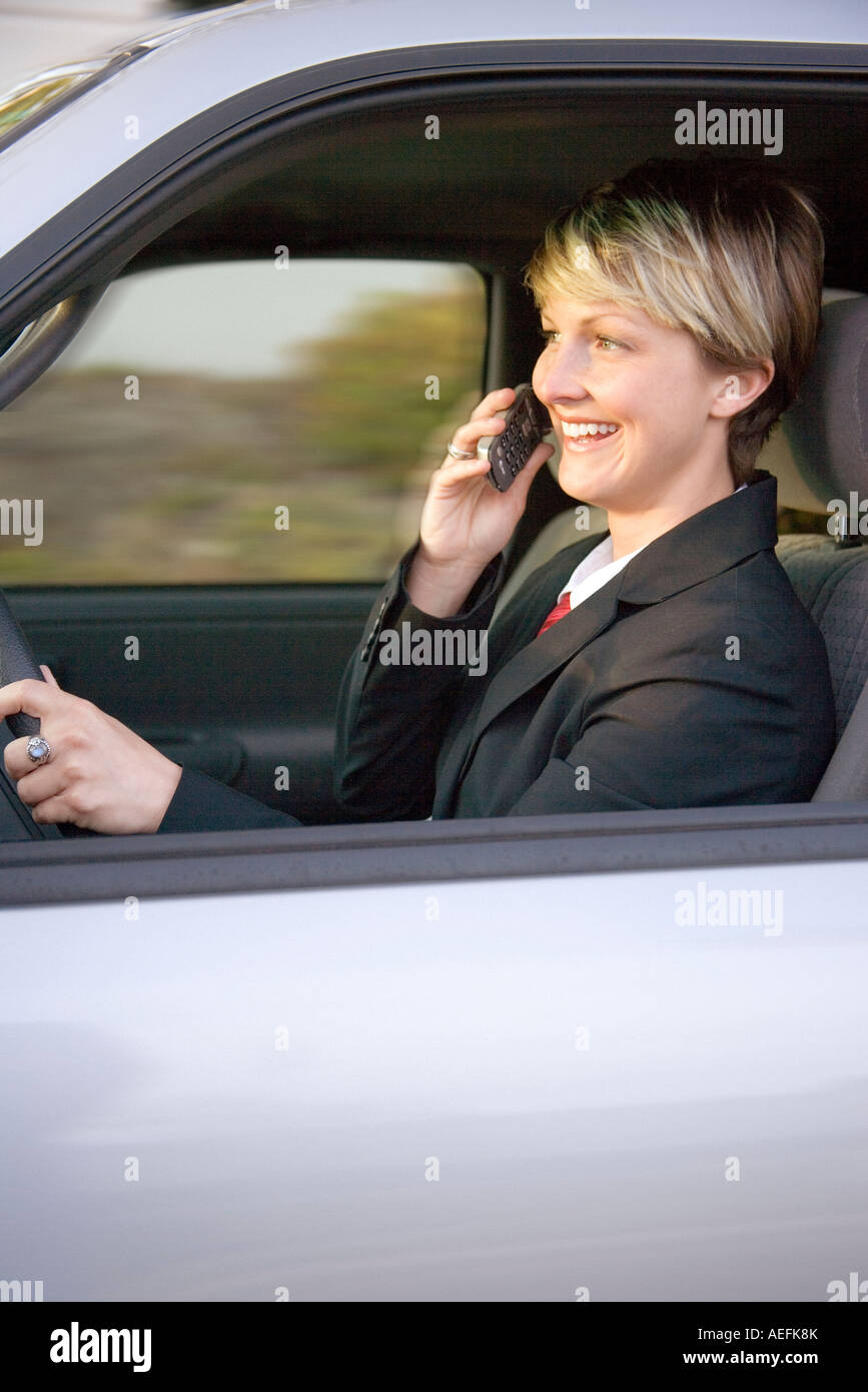 young business woman driving a car and talking on a cell phone Stock Photo