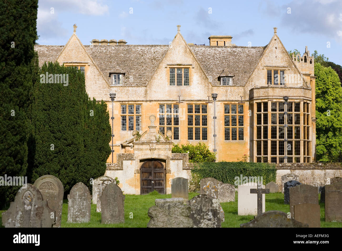 The Jacobean manor of Stanway House seen from the churchyard in the Cotswold village of Stanway, Gloucestershire Stock Photo