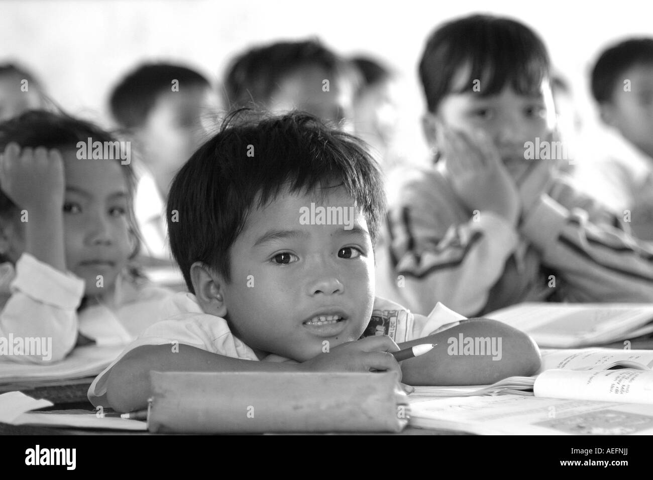 School boy leaning on his desk Stock Photo
