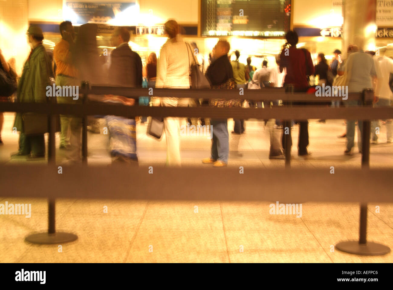 Please Wait In Line People waiting in line in an airport Stock Photo - Alamy