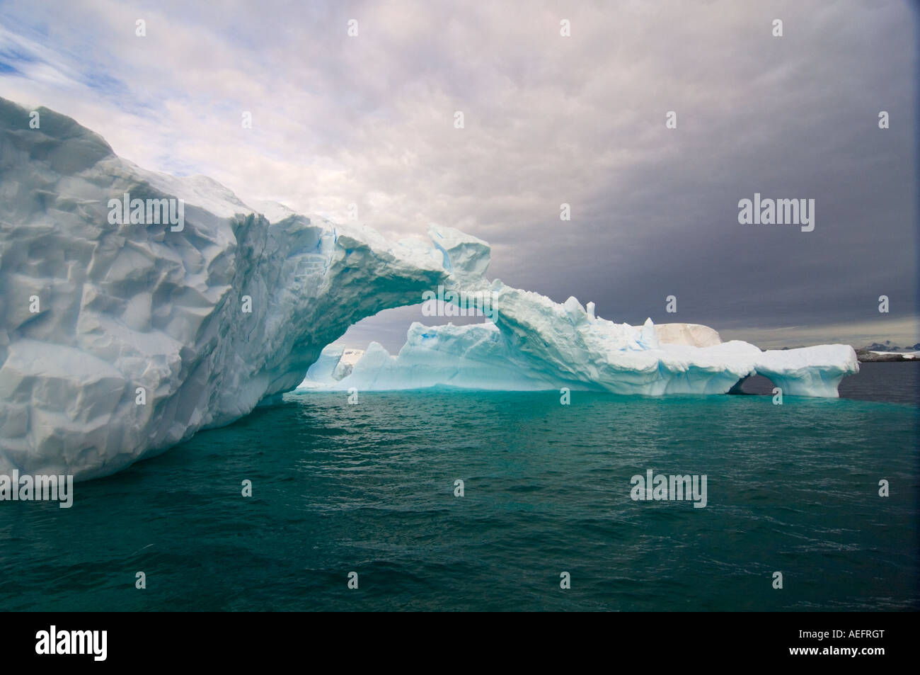 Arched Iceberg Floating Off The Western Antarctic Peninsula Antarctica arched-iceberg-floating-off-the-western-antarctic-peninsula-antarctica
