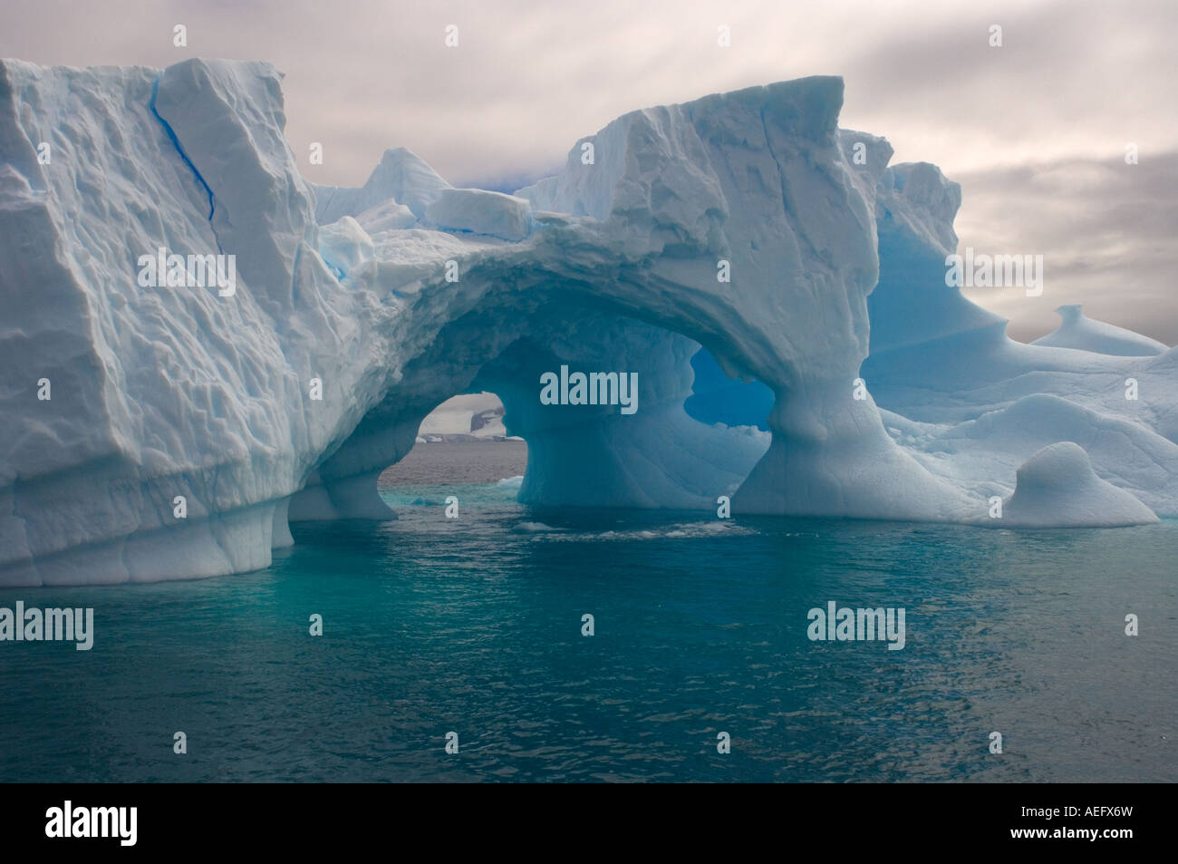 Arched Iceberg Floating Off The Western Antarctic Peninsula Antarctica arched-iceberg-floating-off-the-western-antarctic-peninsula-antarctica