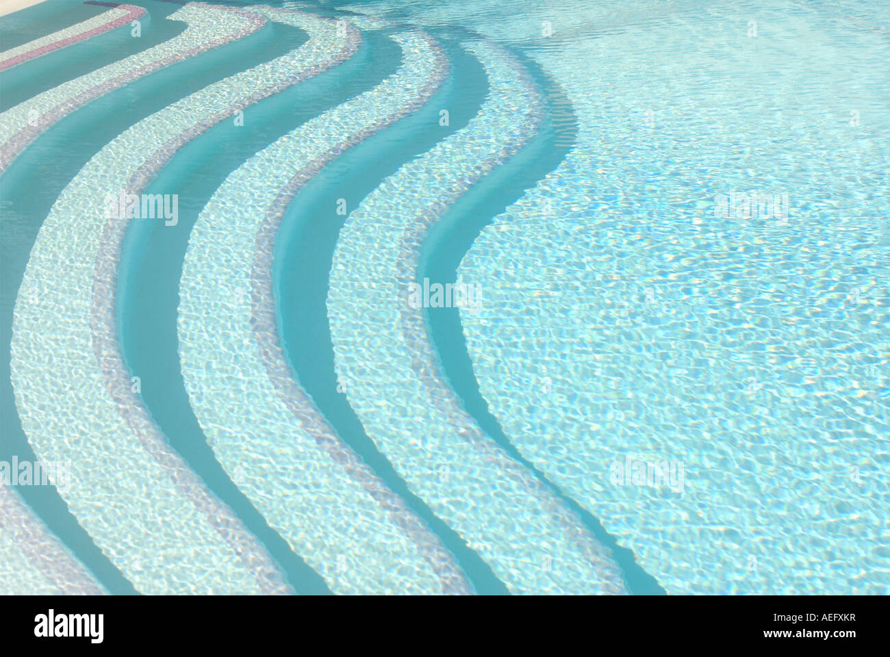 Contemporary patterned bold image of swimming pool steps seen above the water Stock Photo