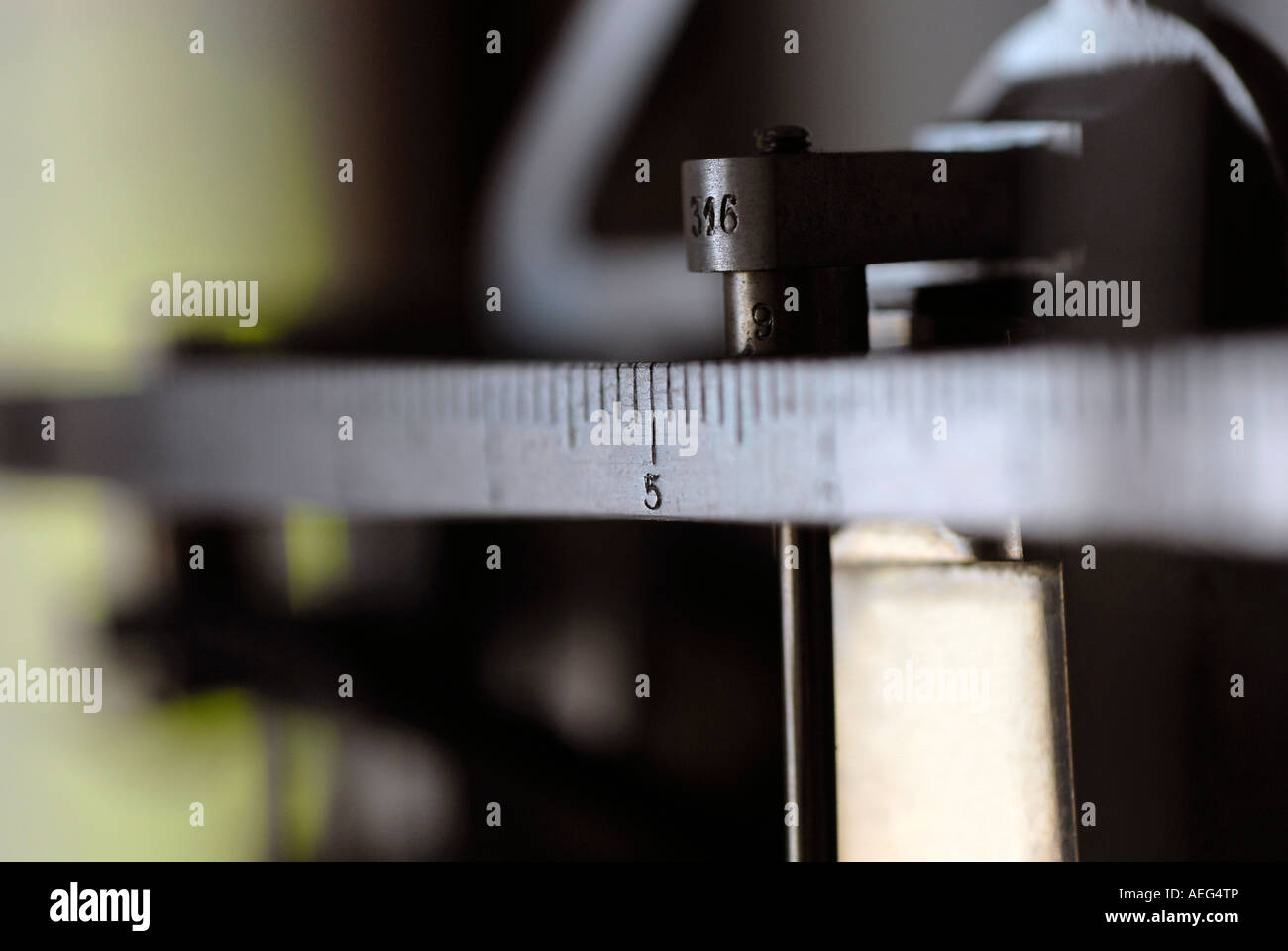 Slider of a mechanical balance scale marking number five Stock Photo