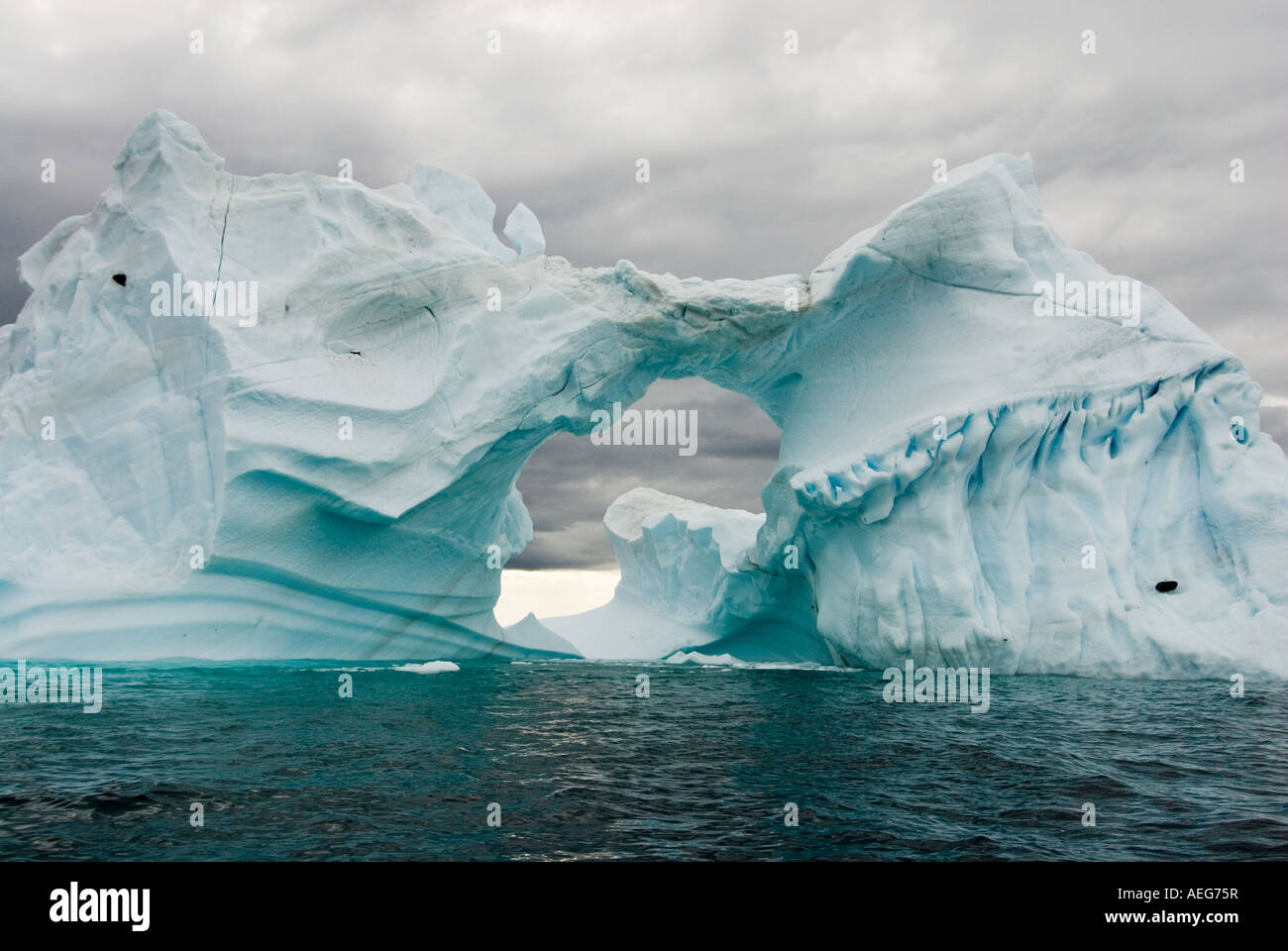 Arched Iceberg Floating Off The Western Antarctic Peninsula Antarctica arched-iceberg-floating-off-the-western-antarctic-peninsula-antarctica