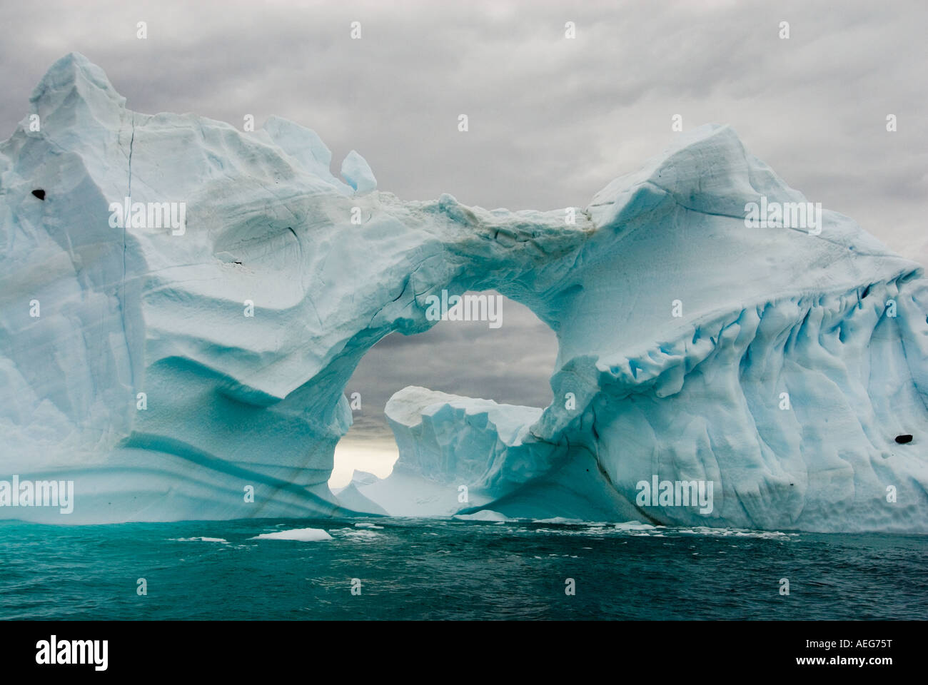 Arched Iceberg Floating Off The Western Antarctic Peninsula Antarctica arched-iceberg-floating-off-the-western-antarctic-peninsula-antarctica