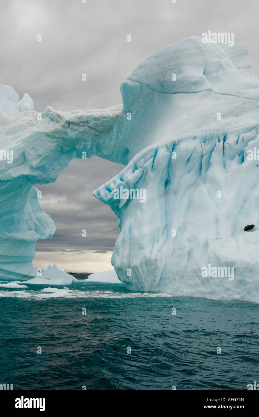 Arched Iceberg Floating Off The Western Antarctic Peninsula Antarctica arched-iceberg-floating-off-the-western-antarctic-peninsula-antarctica