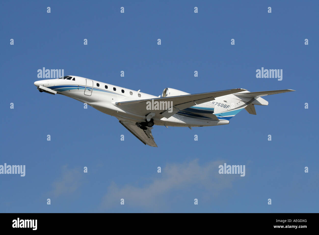 Cessna Citation X business jet plane flying in the air against a blue sky on takeoff Stock Photo