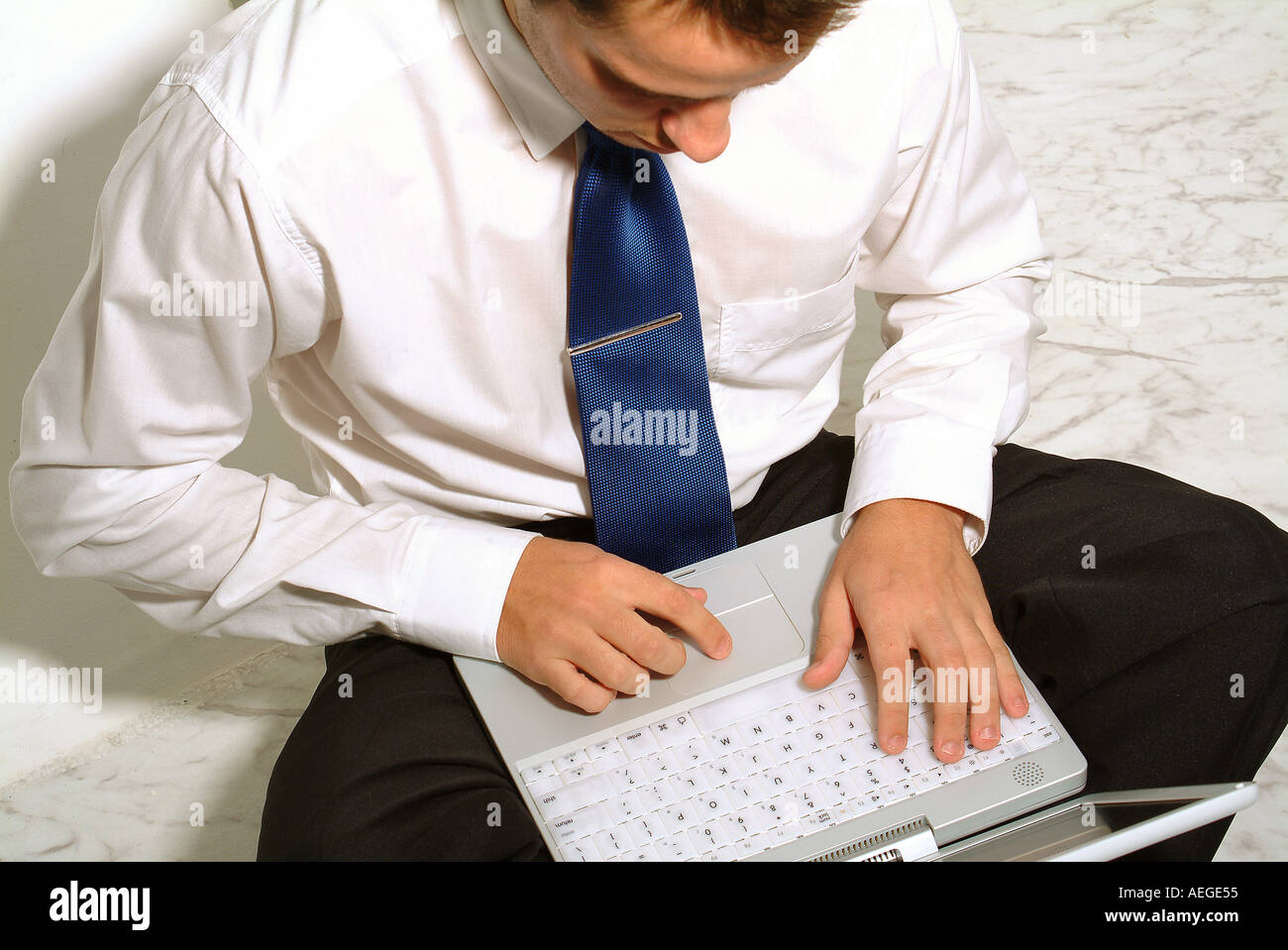 businessman male person man sitting laptop typing shirt tie portable people job work working technology computer business out of Stock Photo