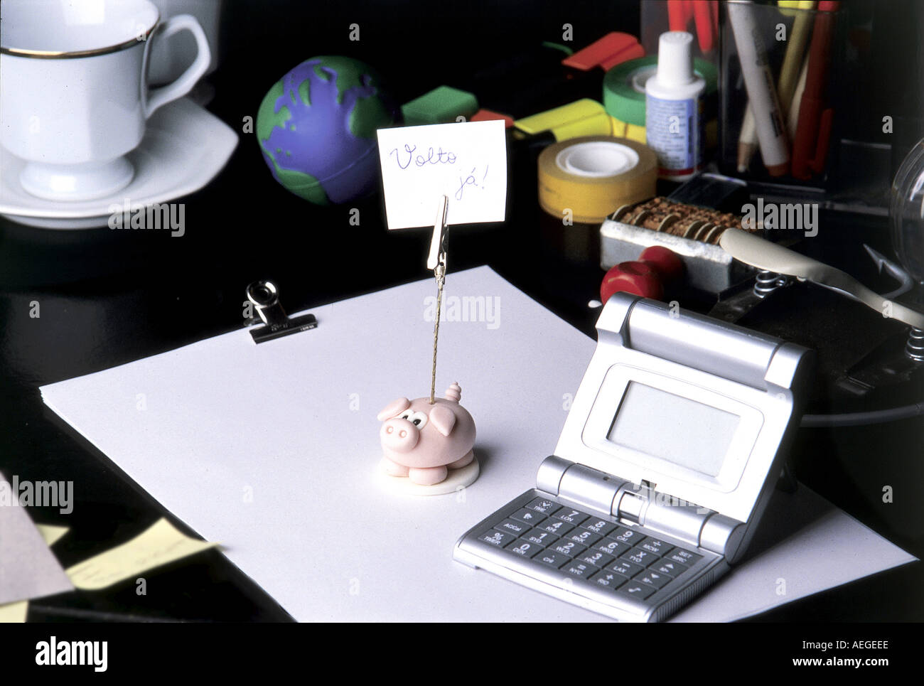 Office desk working calculator clock accent pieces paper stationery cup sellotape office objects be back soon conceptual time bu Stock Photo