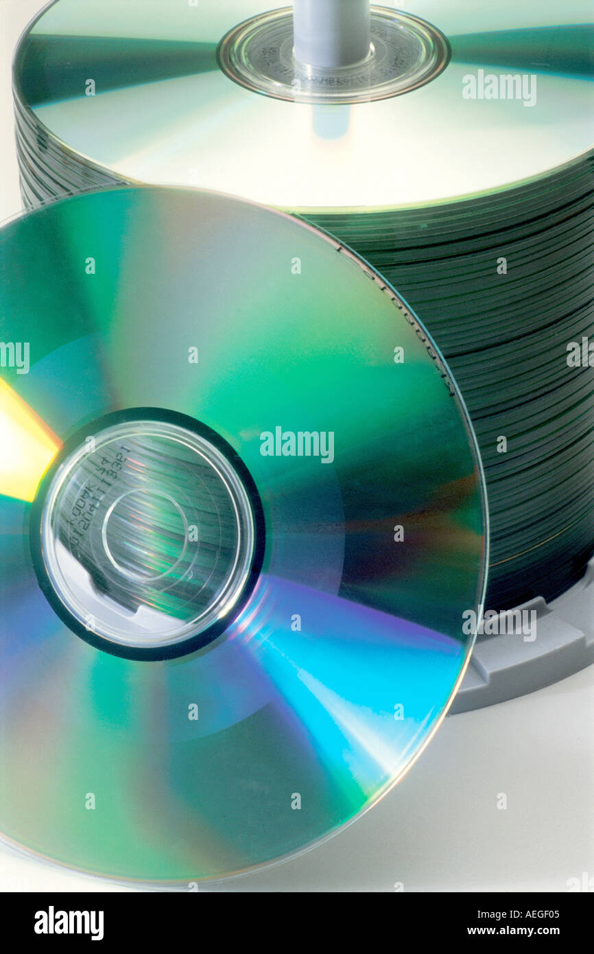 Office cdrom cd rom cd compact disk disks reproduction copies pile media storage round shiny reflective metallic music data tech Stock Photo
