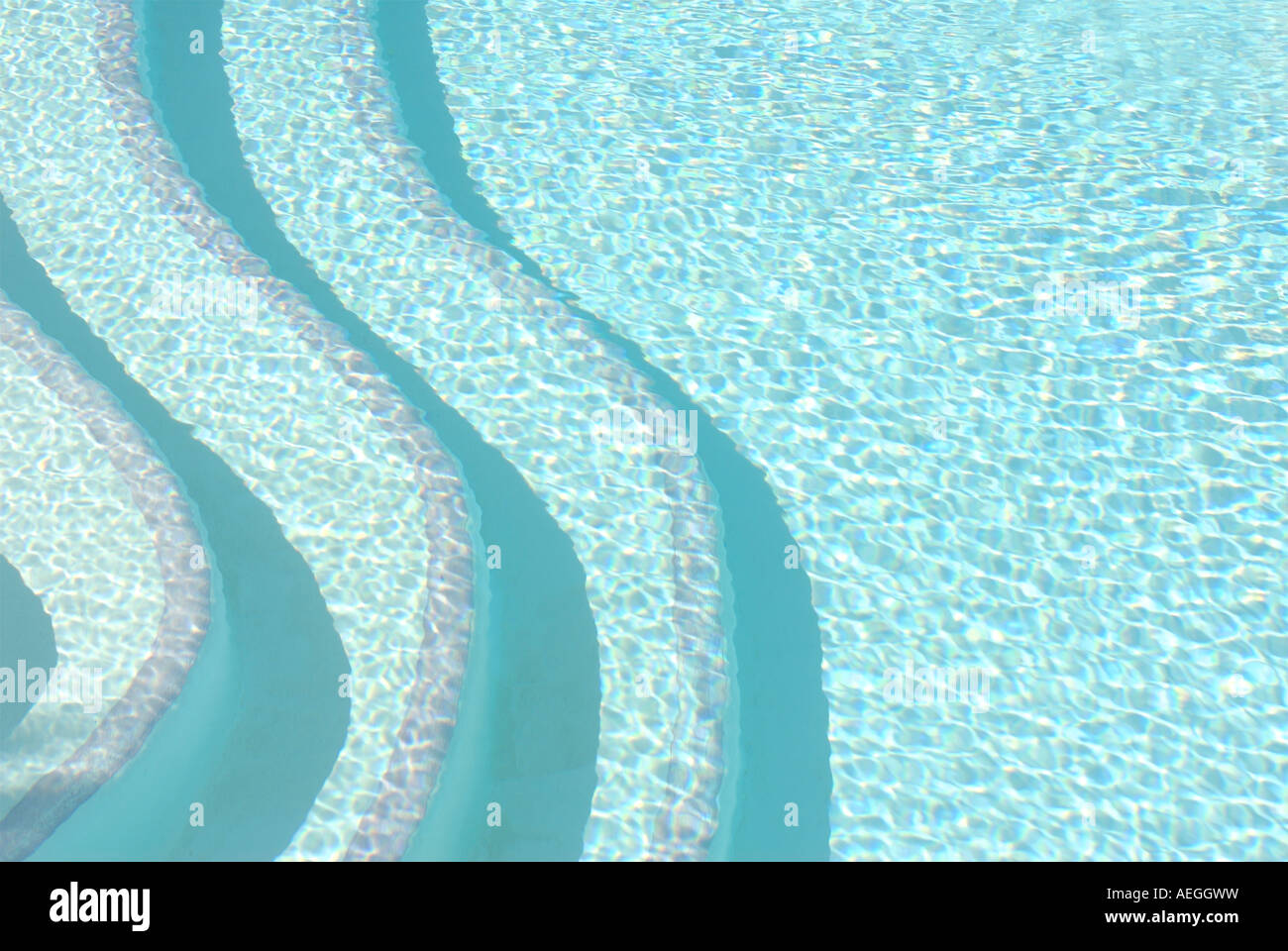 Contemporary patterned bold image of swimming pool steps seen above the water Stock Photo