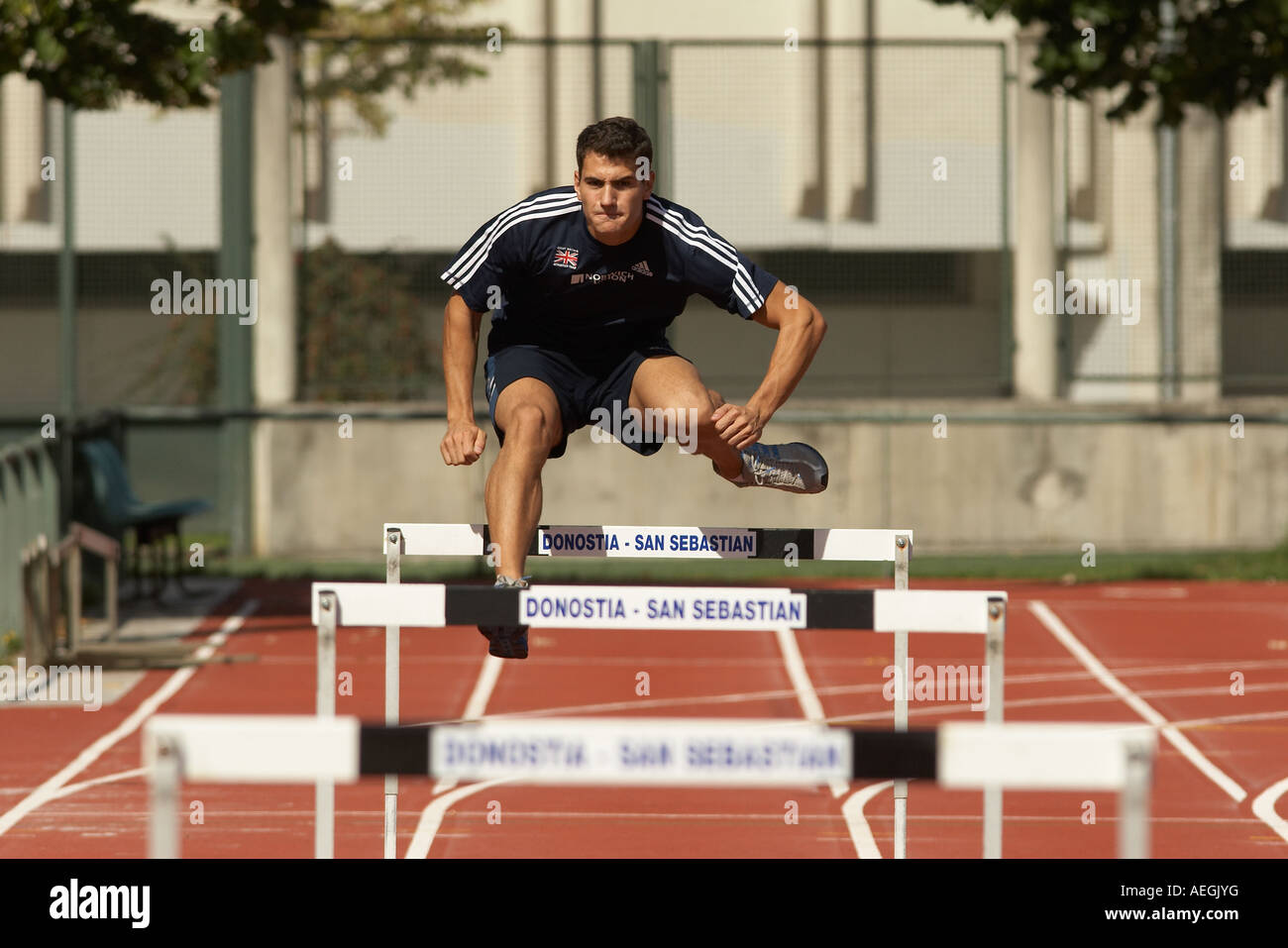 Track and field Man doing hurdles Stock Photo Alamy