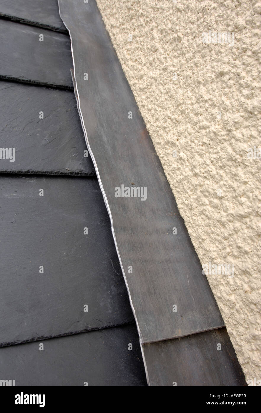 A SLATE ROOF JOINING A RENDERED WALL WITH LEAD FLASHING Stock Photo