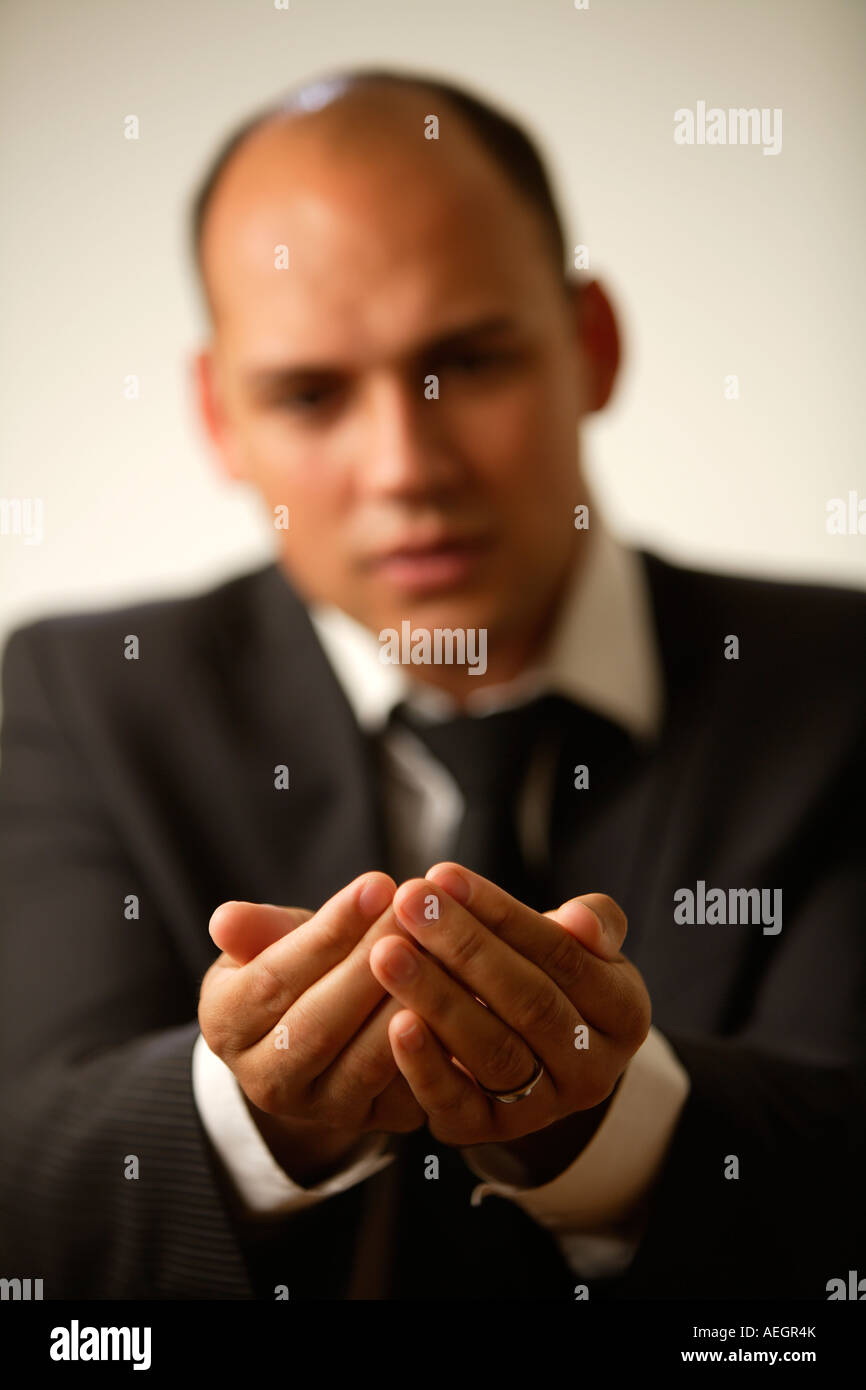 Young Businessman holding out cupped hands. Stock Photo