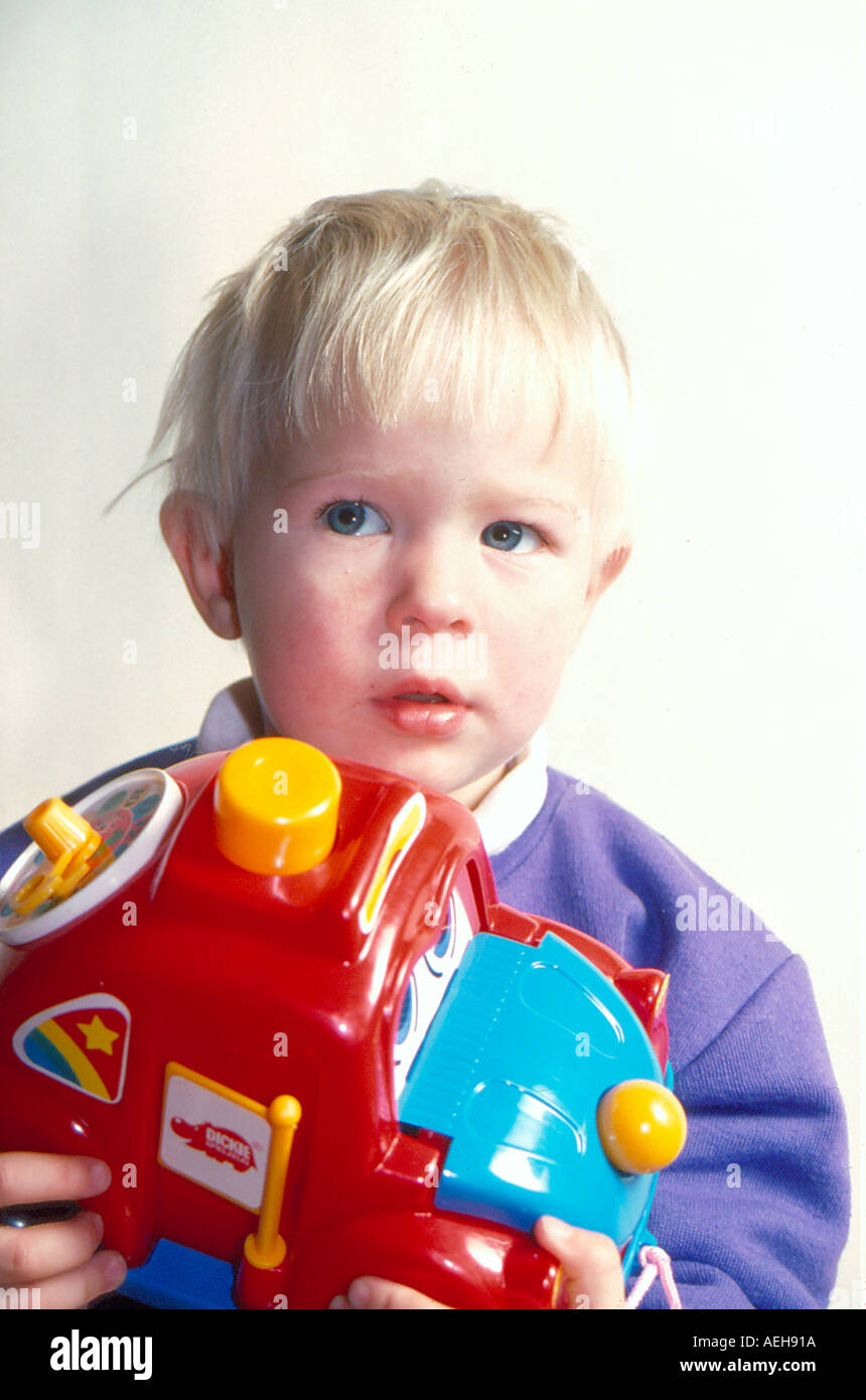 sceptically looking child holding  toy. Photo by Willy Matheisl Stock Photo