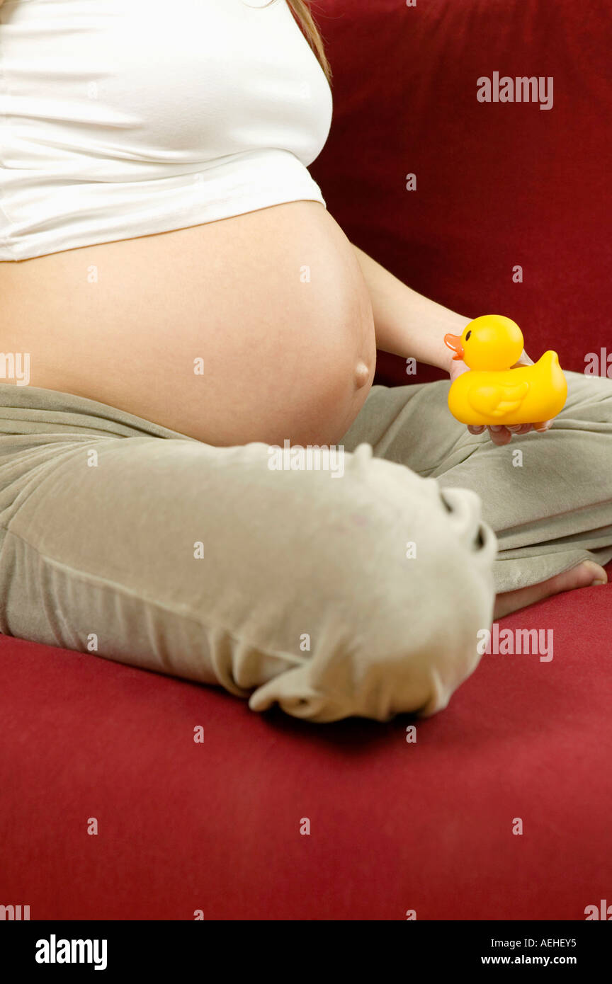 Pregnant woman holding rubber duck Stock Photo