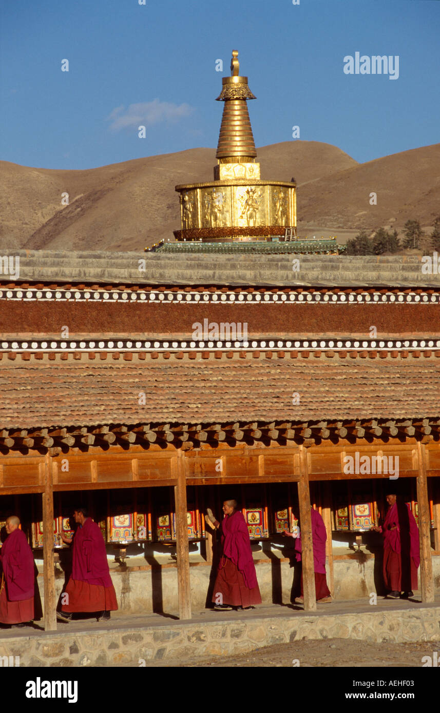 Labrang Monks praying at the Western Prayer wheels with the Ser Kung Golden ...