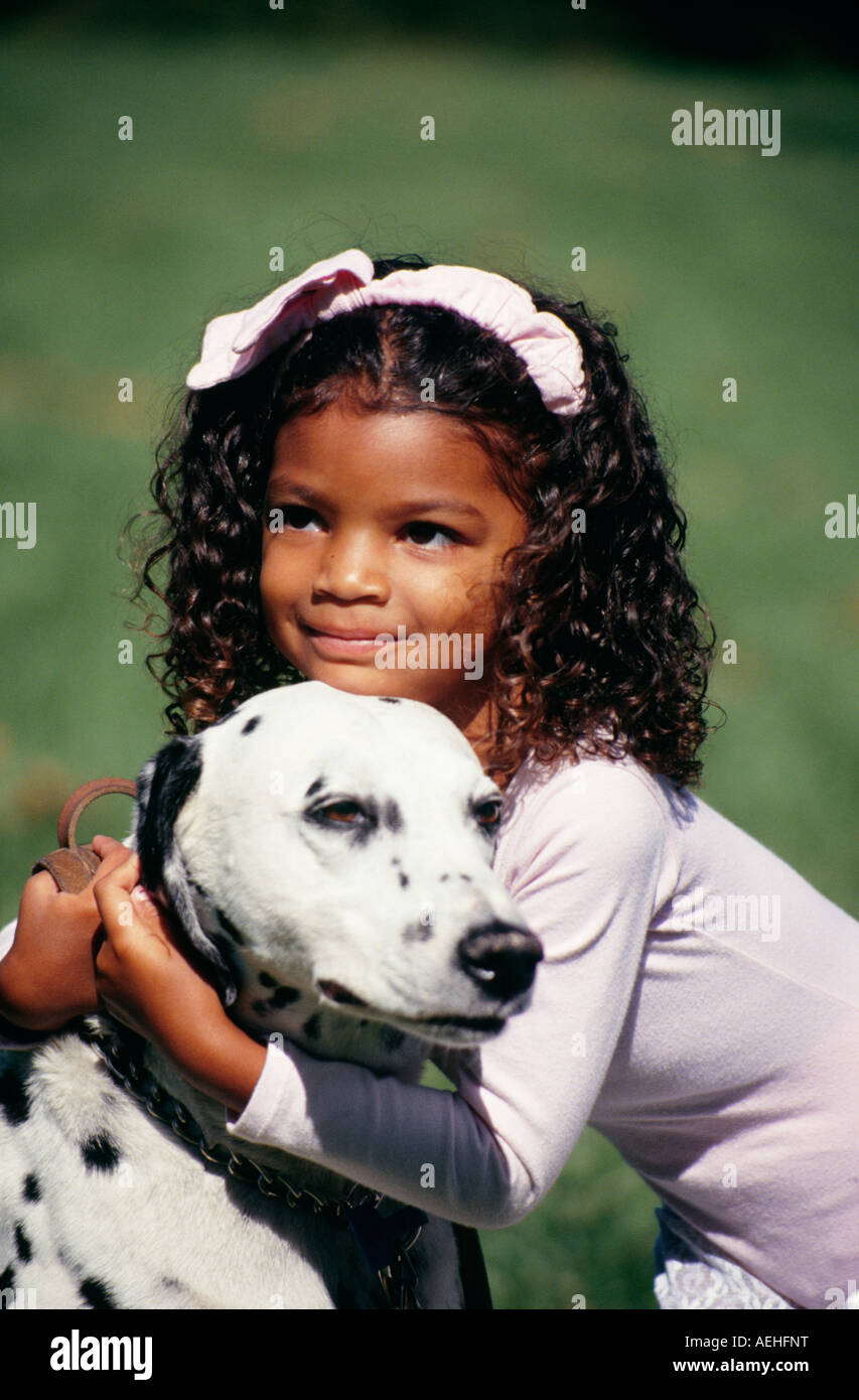Close up closeup diversity multicultural multi Child pet Girl playing play plays dog smiling cute showing affection front USA US MR  © Myrleen Pearson Stock Photo