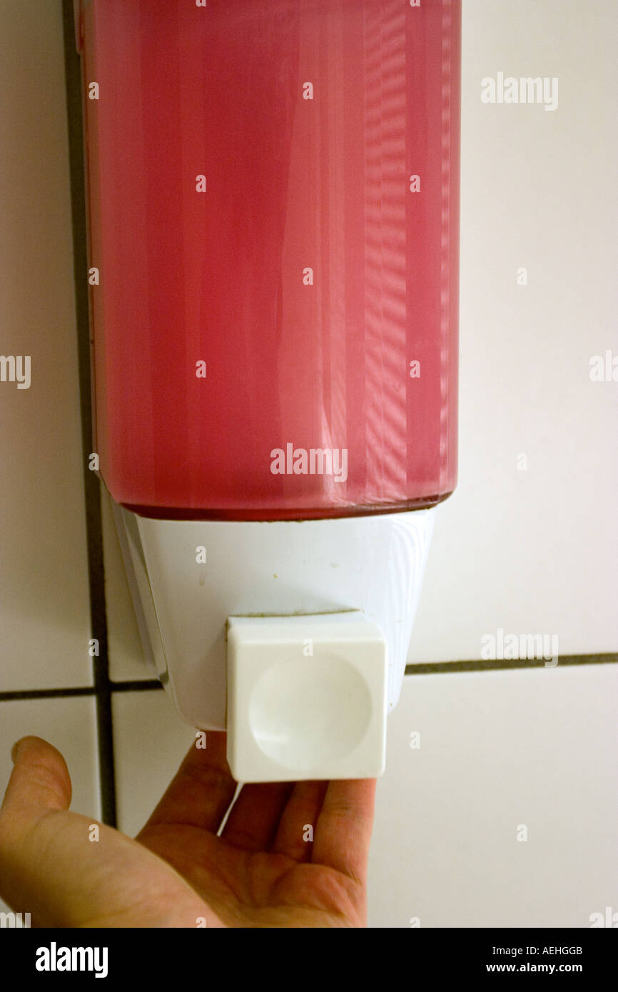 clean sink with pink soap dispenser and hand fingers Stock Photo Alamy