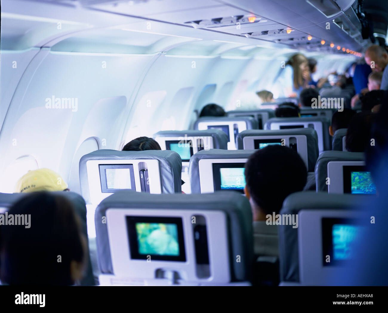Passengers inside airplane watching mini TV  Stock Photo
