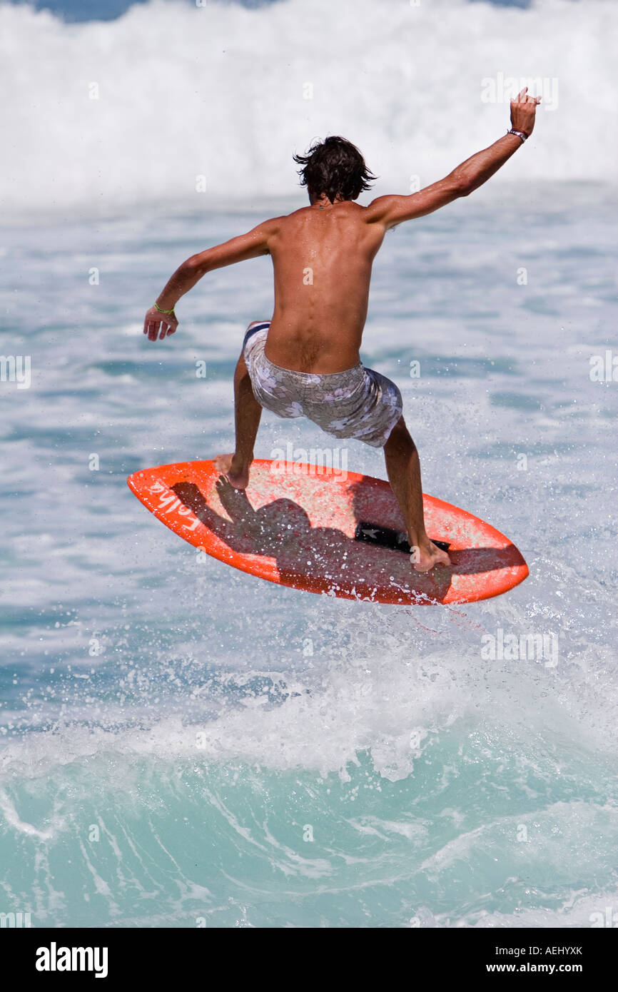 Surfer surfing on breaking wave using a skimboard Stock Photo Alamy