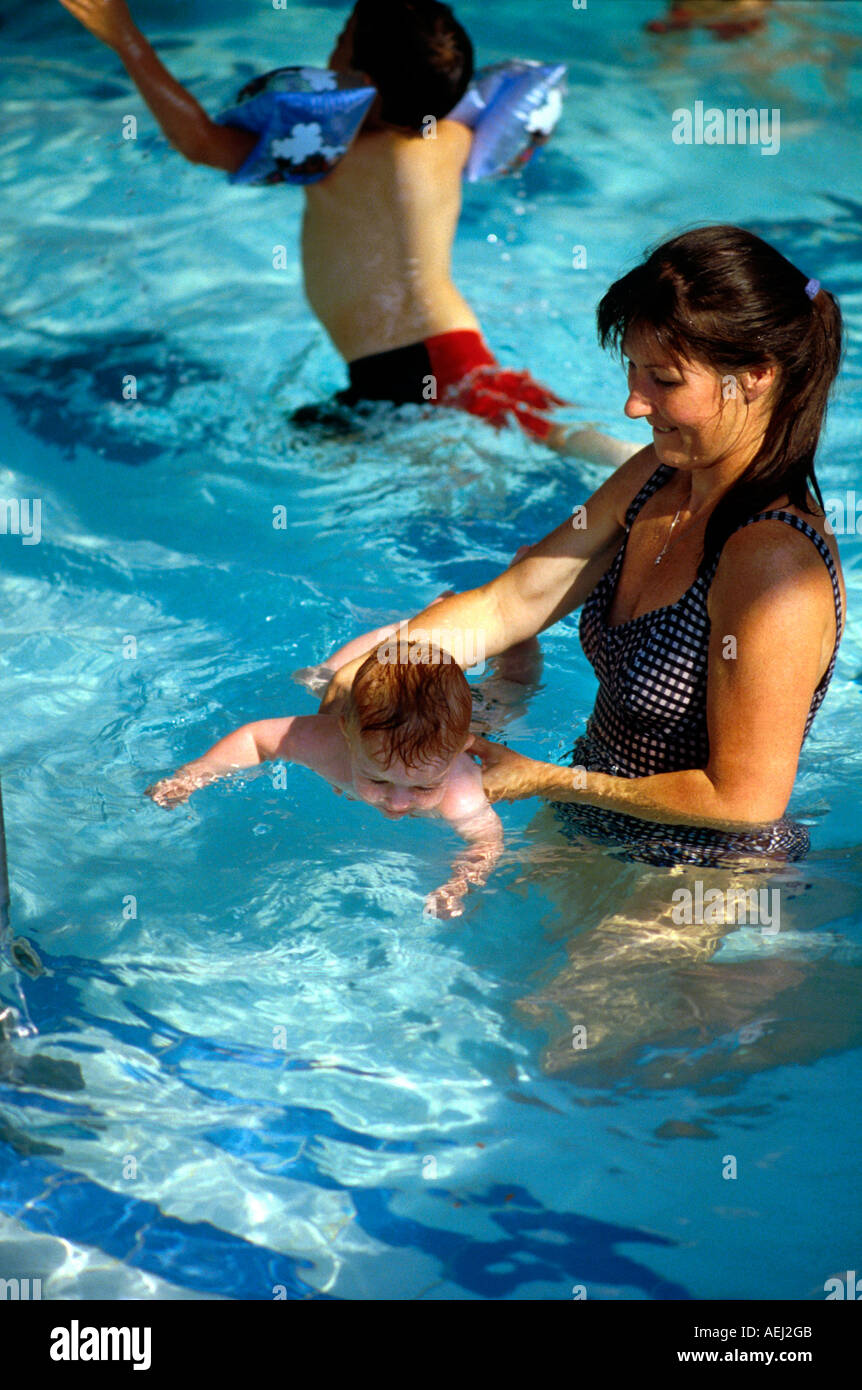 Mum giving baby first swimming lesson Stock Photo