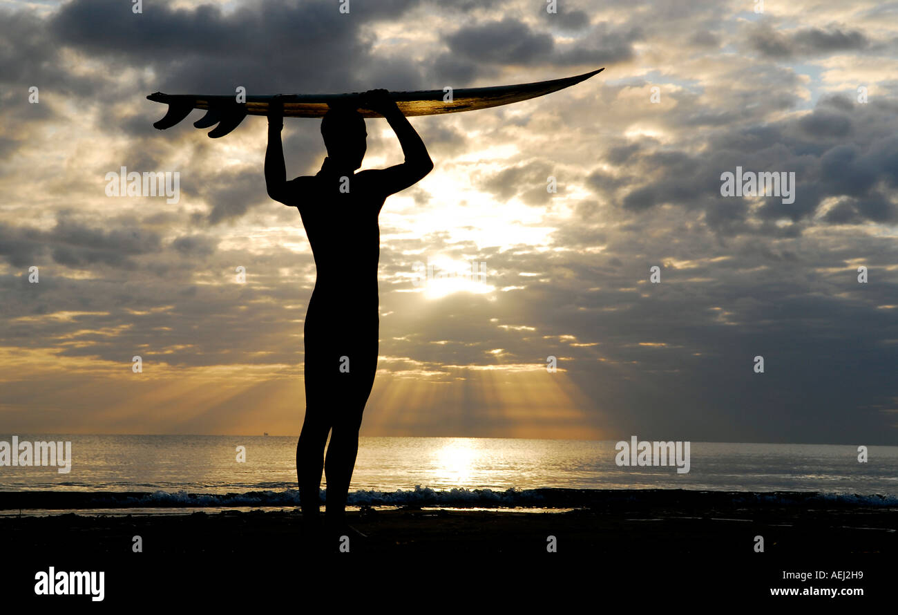 A surfer stands at the beach at sunrise at John Muir country park, Belhaven Bay, near Dunbar in East Lothian, east of Scotland. Stock Photo