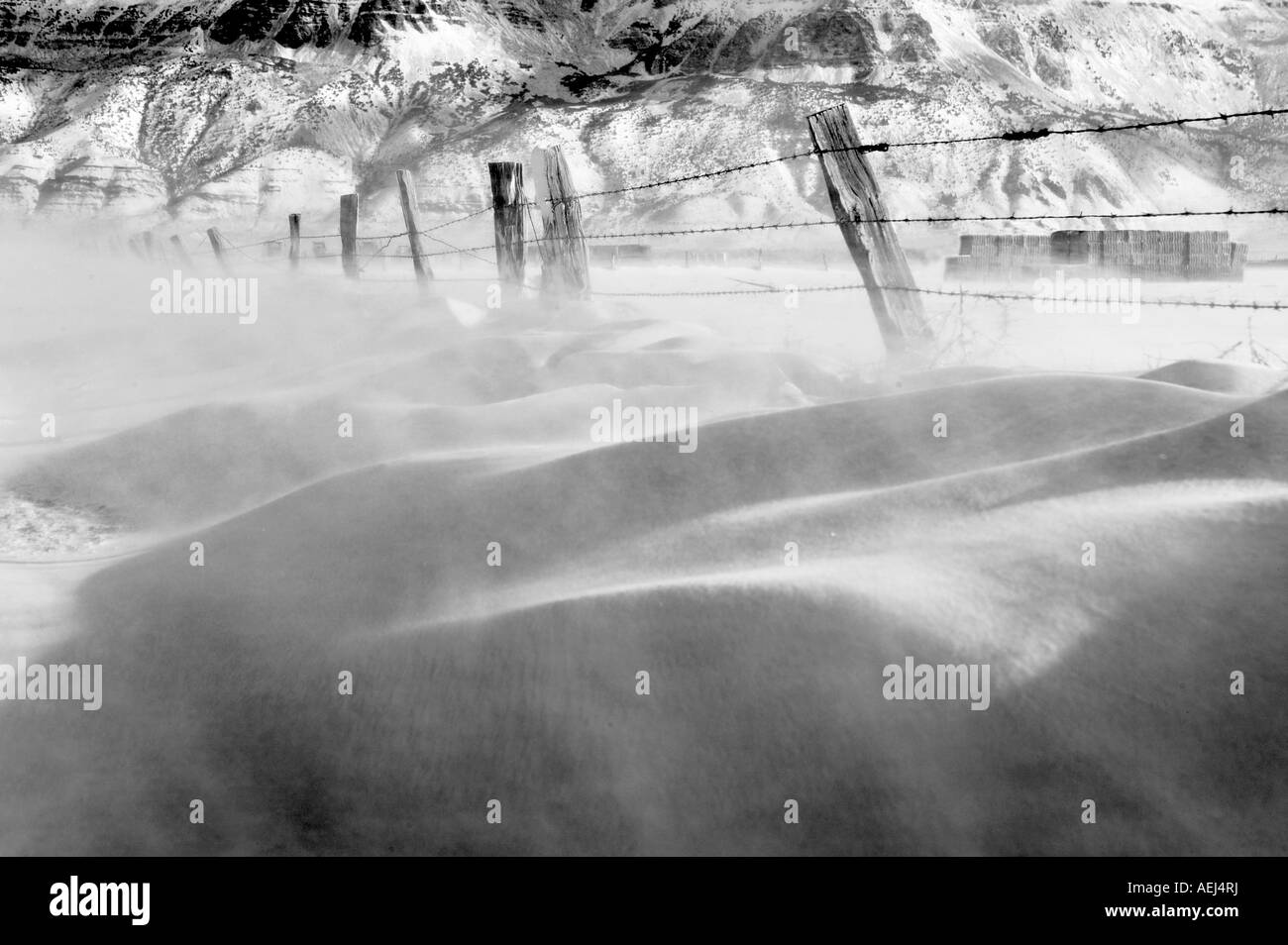 Blowing snow and fence line and Hart Mountain Warner Valley Oregon Stock Photo