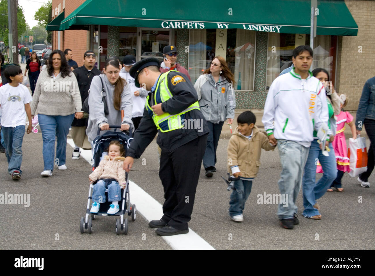 Policeman assisting pedestrians across street. Cinco de Mayo Fiesta. 'St Paul' Minnesota USA Stock Photo