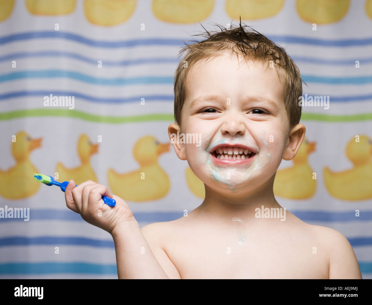 Boy with toothbrush in bathroom smiling Stock Photo Alamy