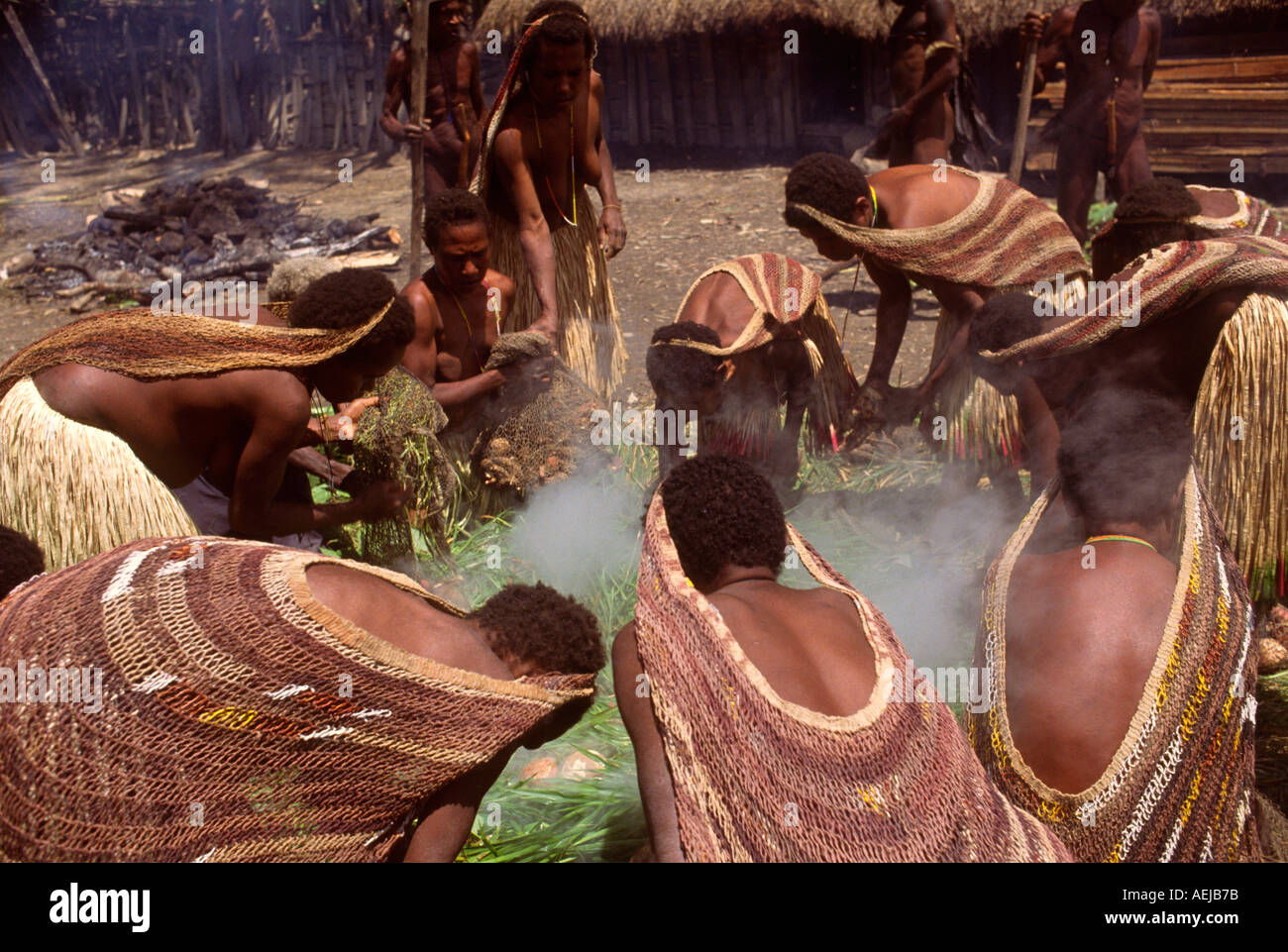 Dani women cooking sweet potatoes for pig feast Bolokme Baliem Valley Irian Jaya Indonesia Stock Photo