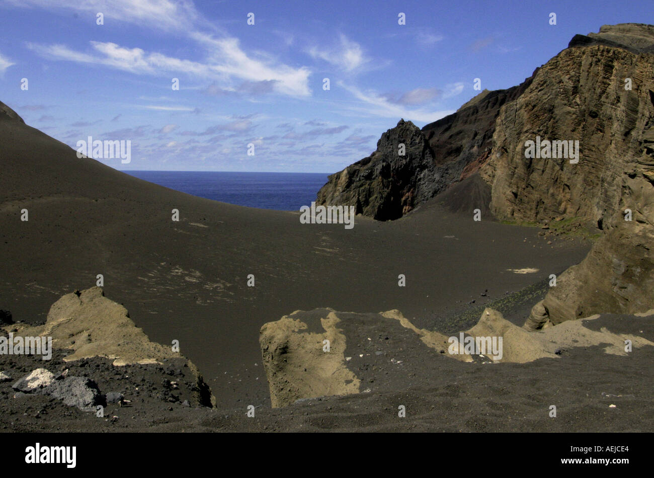 gray inactive vulcano over the sea and blue sky Stock Photo - Alamy
