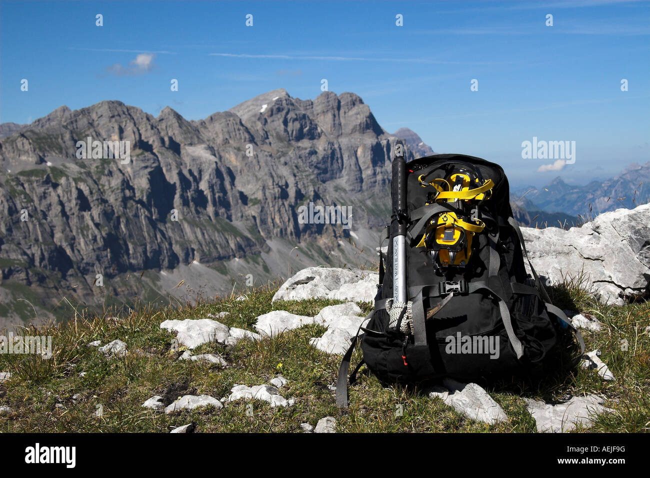 Backpack in front of mountains of the Klausen Pass, Canton of Glarus, Switzerland Stock Photo