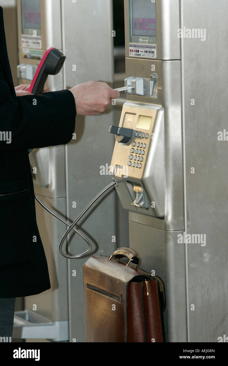 A person is paying his phonecall at a public telephone of the German Telekom Stock Photo