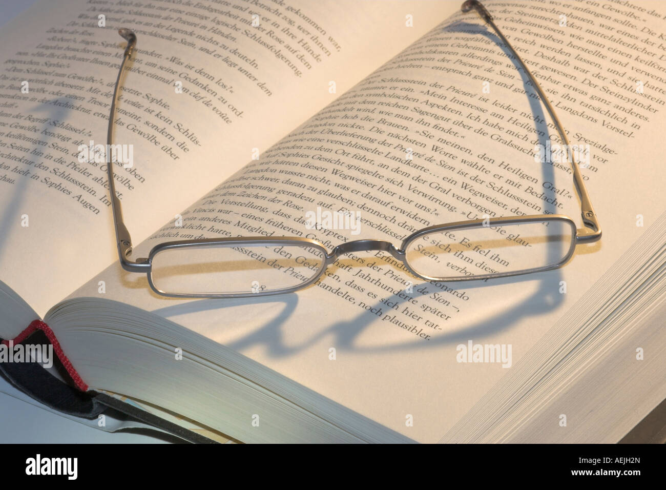 Reading glasses lying on an open book Stock Photo