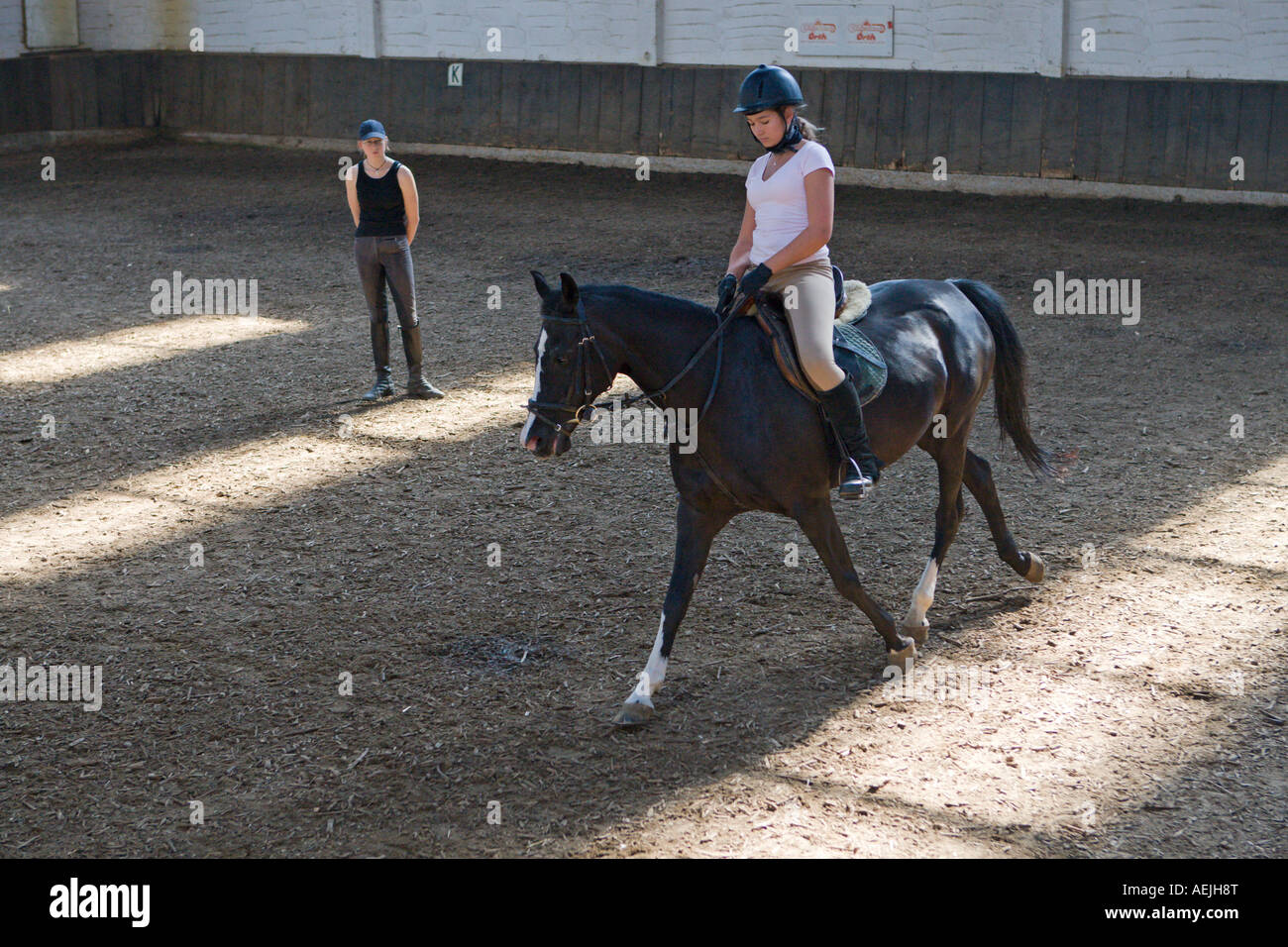 Teenager with the riding lessons in a indoor riding arena, Germany. Stock Photo