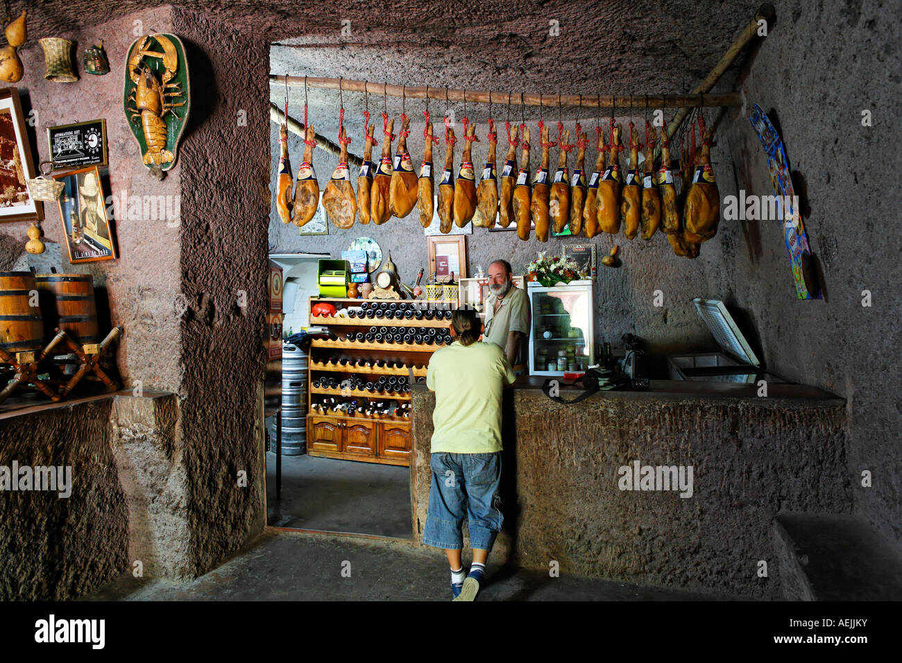 Cave bar with ham, Cuevas Bermejas in Barranco de Guayadeque, Gran Canaria, Spain Stock Photo