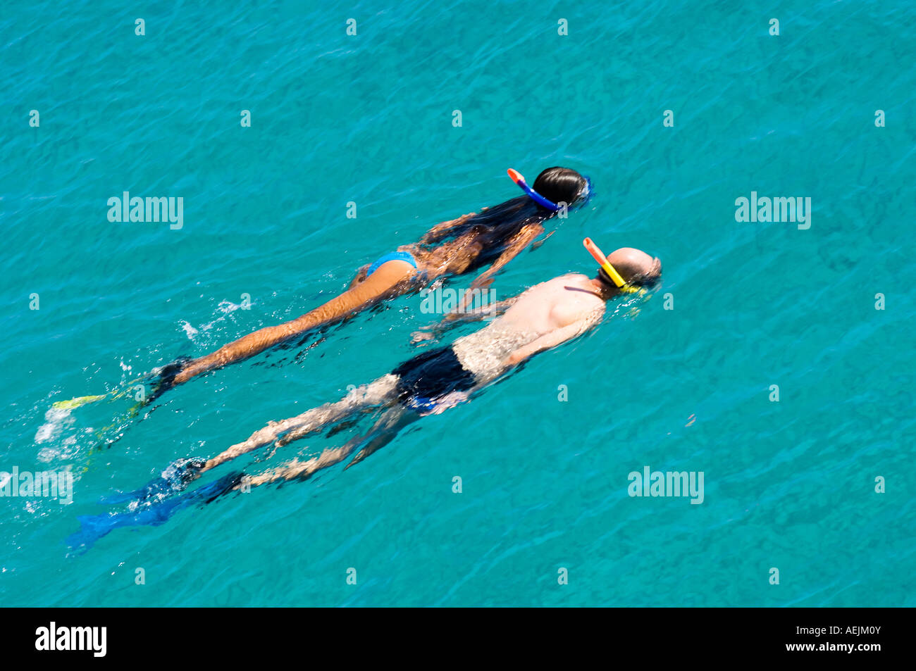 Swimming couple, a man and a woman swim with snorkel and fins in turquoise water of the mediterranean sea, Greece. Stock Photo