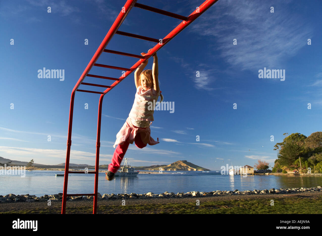 Child Playing on Monkey Bars Karitane Otago South Island New Zealand Stock Photo