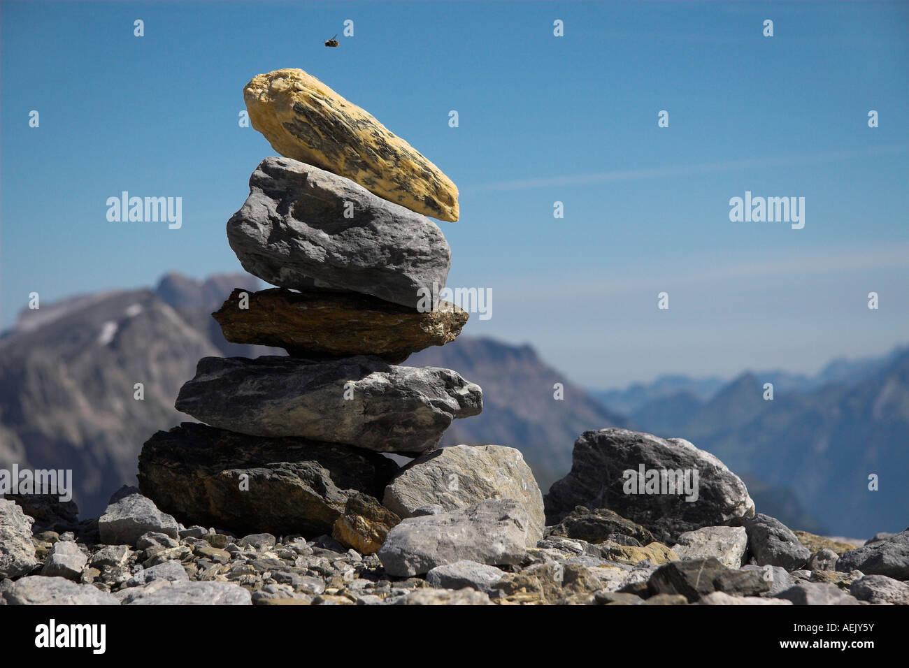 Track marker/stone man in the Glarner alps/Switzerland with bee in the approach in Stock Photo