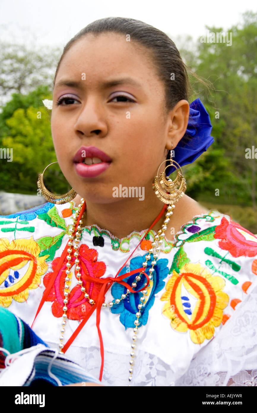 Thoughtful Chicana teen age 16 wearing beautiful Mexican dress in the parade. Cinco de Mayo Fiesta. 'St Paul' Minnesota USA Stock Photo