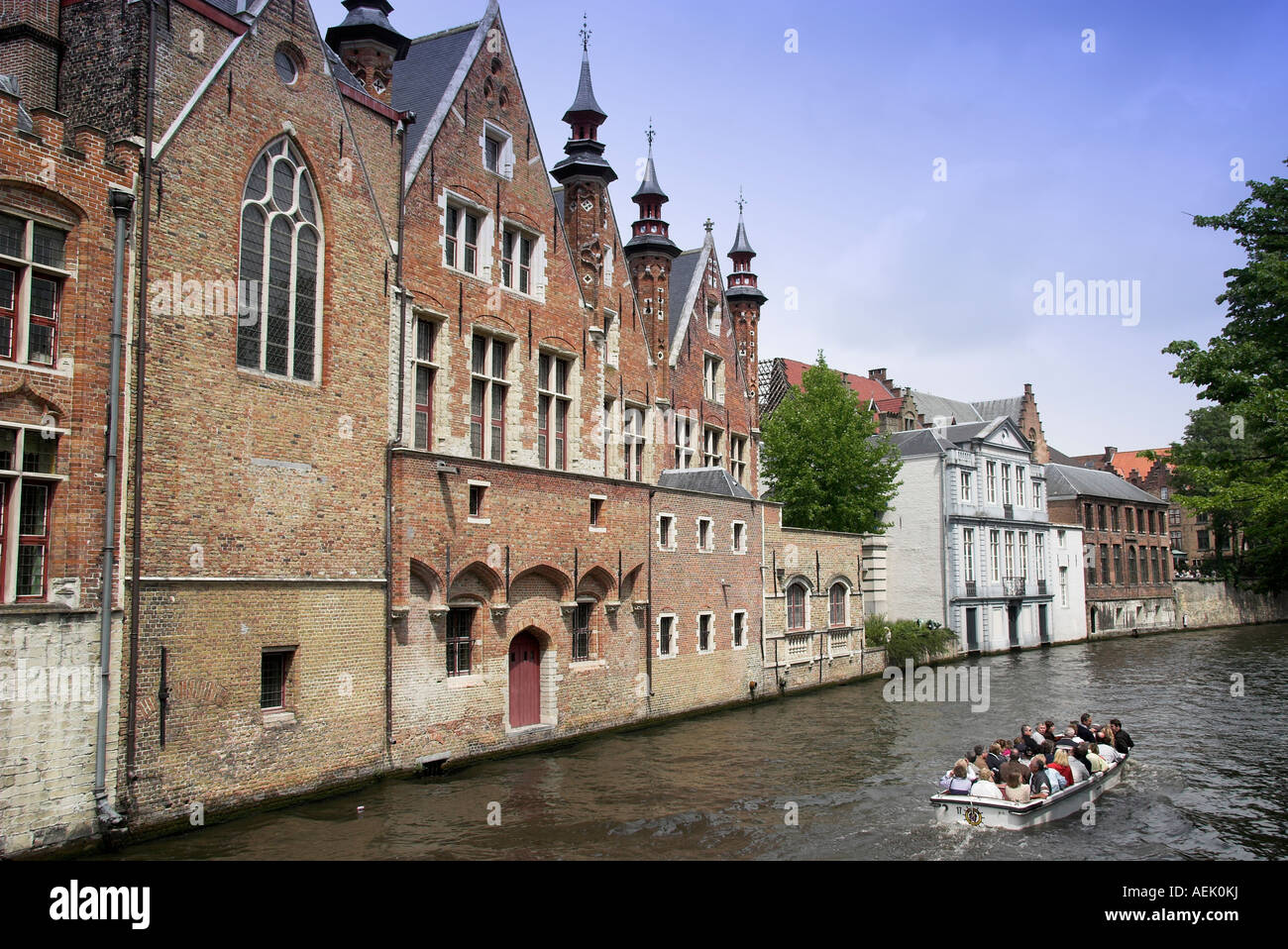 Cruise boat with passengers along the canal in Bruges, Flanders, Belgium Stock Photo