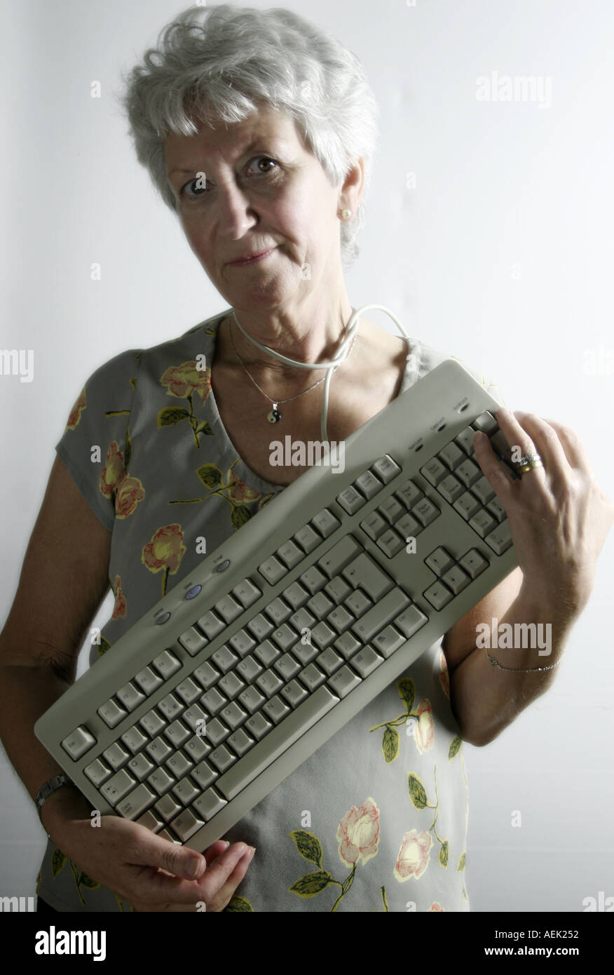 Woman looking dumbfounded with keyboard around her neck Stock Photo Alamy