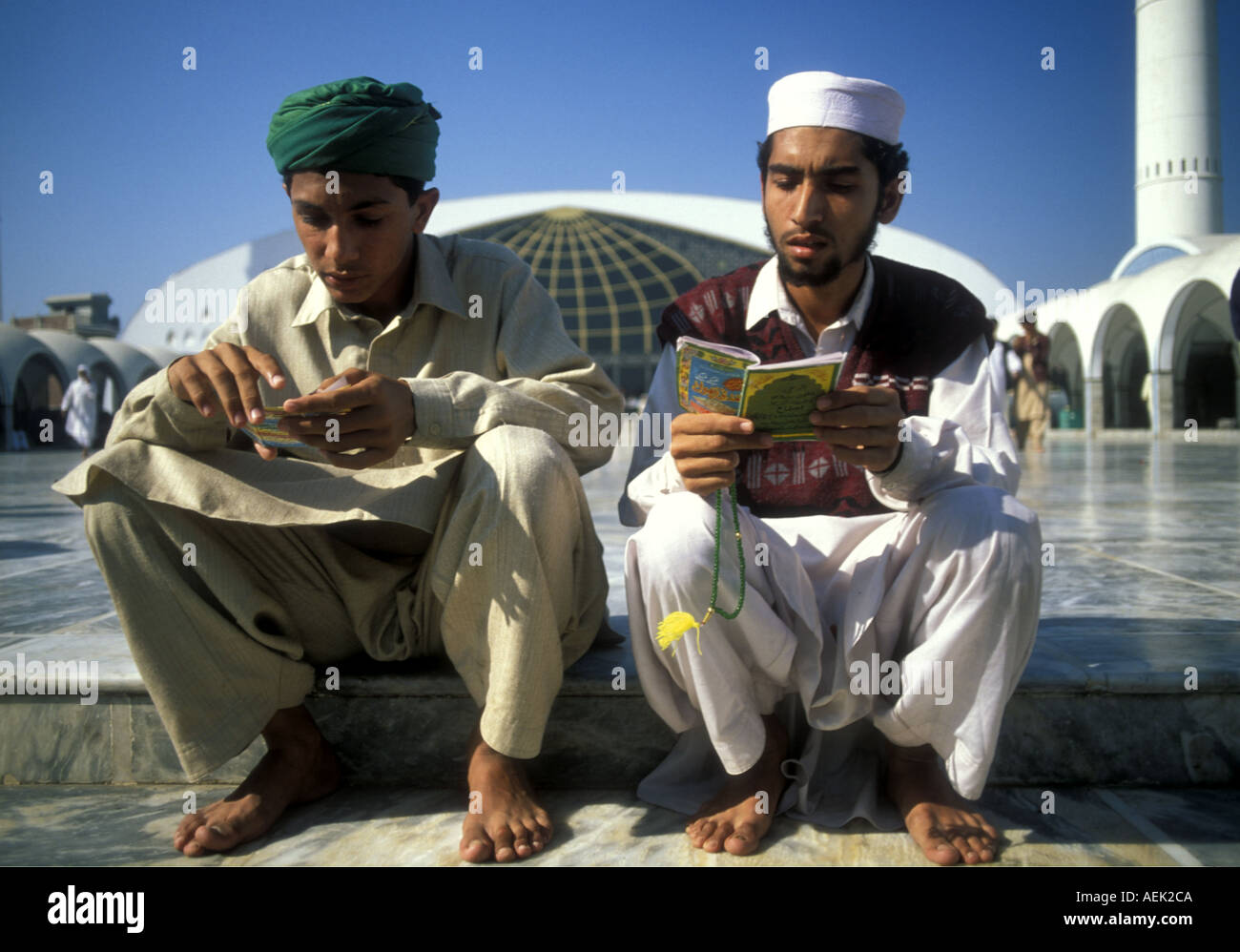 Young men reading the Quran, Data Durbar shrine of Ali Hujwiri,, an 11th century Sufi saint from Ghazni in present-day Afghanistan. Lahore, Pakistan Stock Photo