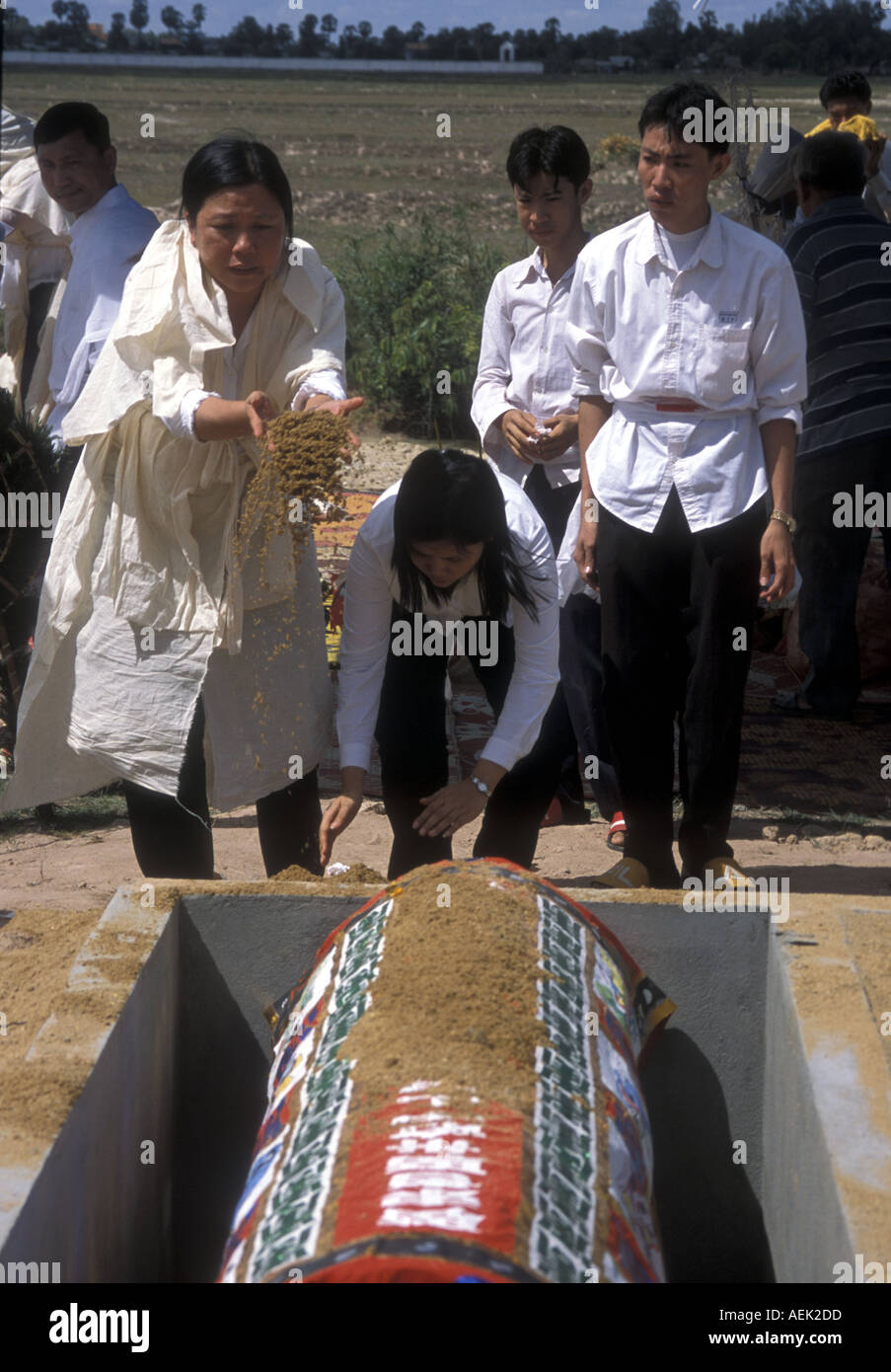 TAOISM relatives throw sand onto the coffin at a Chinese funeral in Cambodia Stock Photo